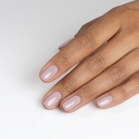 Hand mit lackierten Nägeln. Rosa Nagellack auf fünf Fingern. Helle Haut, weißer Hintergrund.