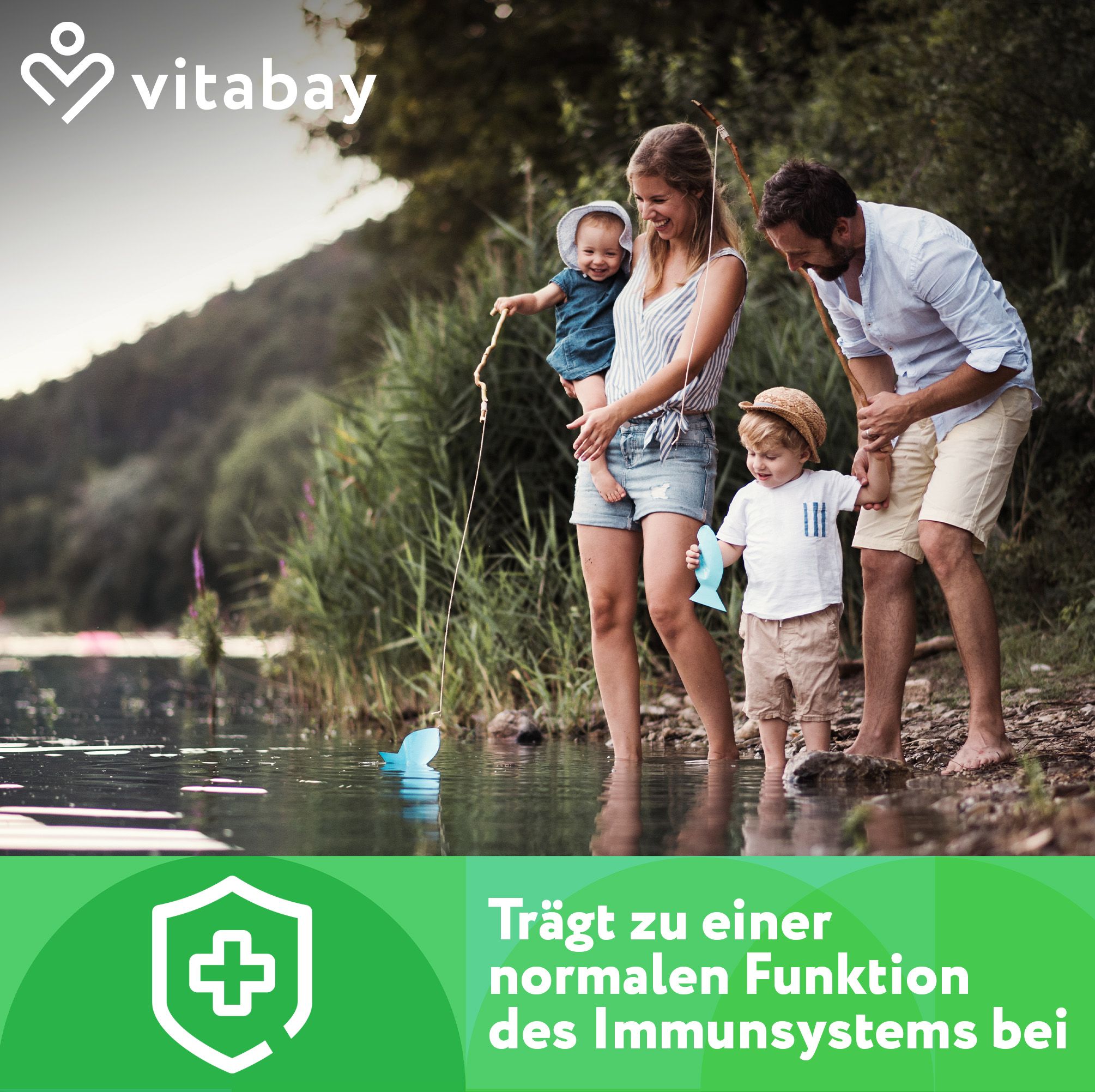 Familie am See. Text: "Trägt zu einer normalen Funktion des Immunsystems bei". Logo: grünes Schild mit Kreuz.