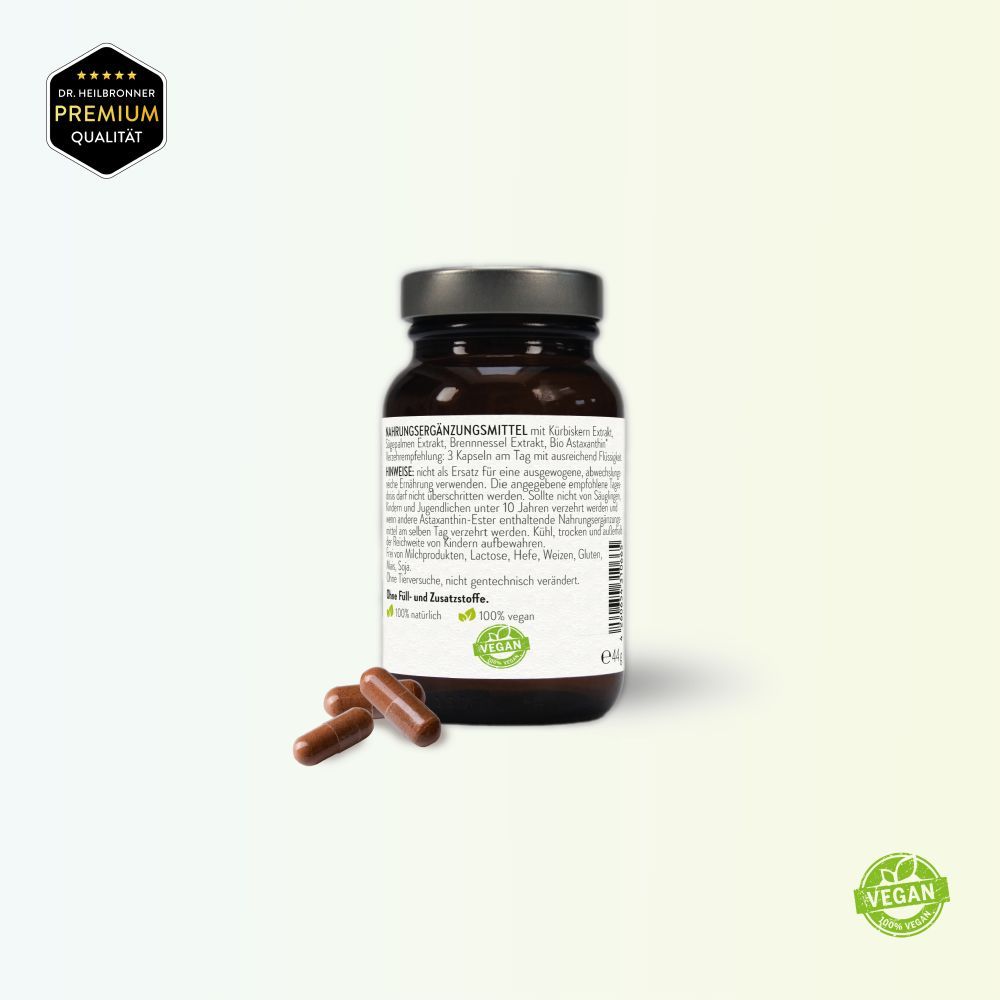 Rückseite der Flasche mit Inhaltsangaben. Braune Kapseln daneben. Premium Qualität Siegel, Vegan-Siegel. Enthält Kürbiskern, Sägepalme, Brennnessel.