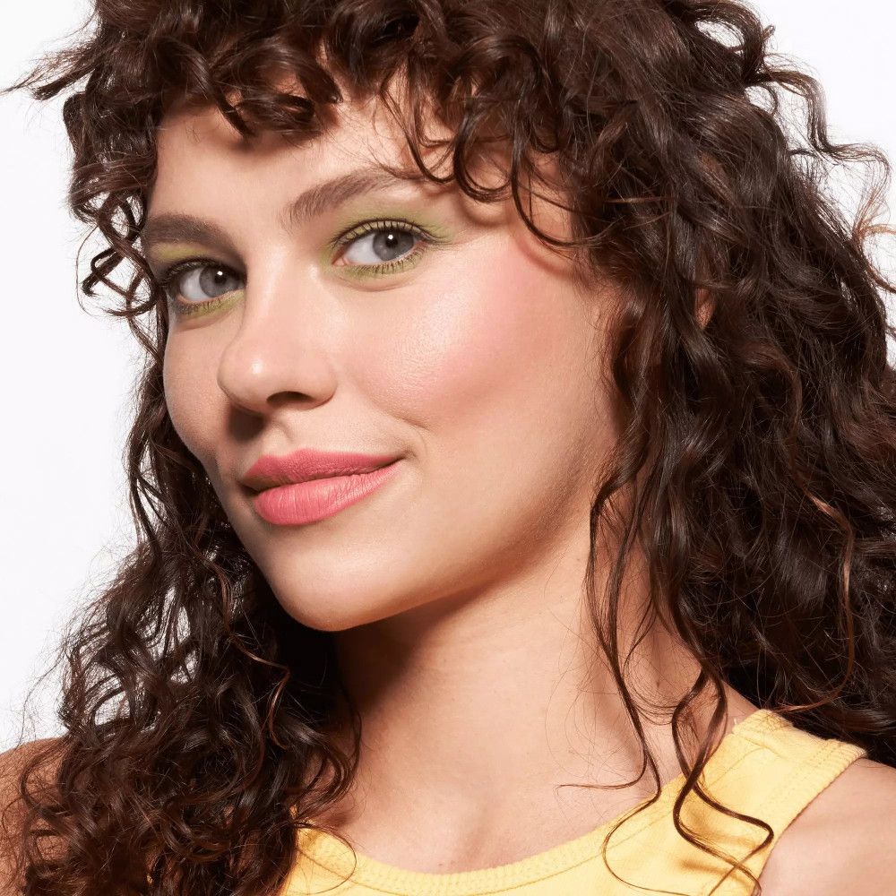 Porträt einer Frau mit Make-up. Grüner Lidschatten, rosa Lippen. Kosmetisches Produkt.