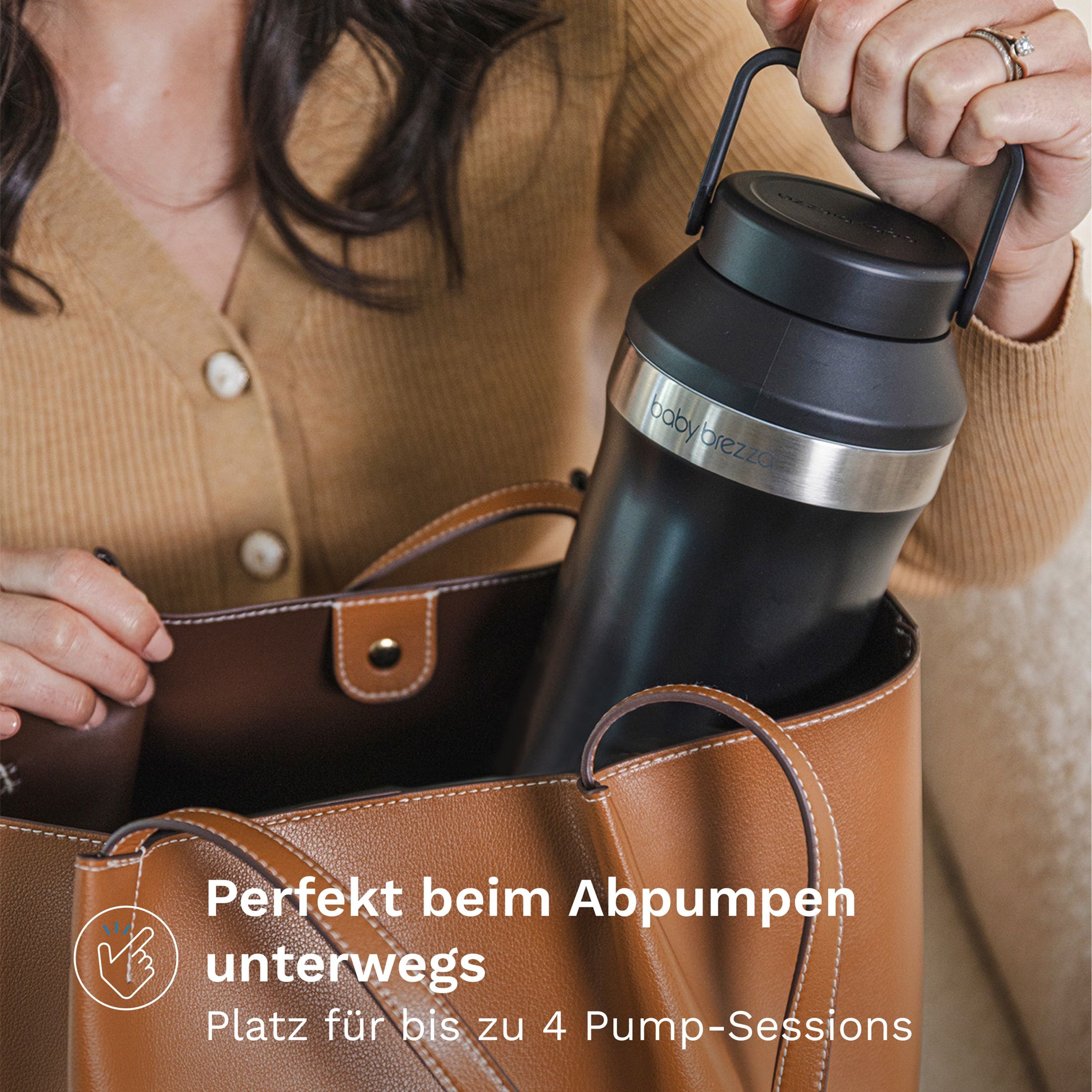 Schwarze Thermosflasche mit silbernem Band und Henkel, wird in eine Tasche gestellt.