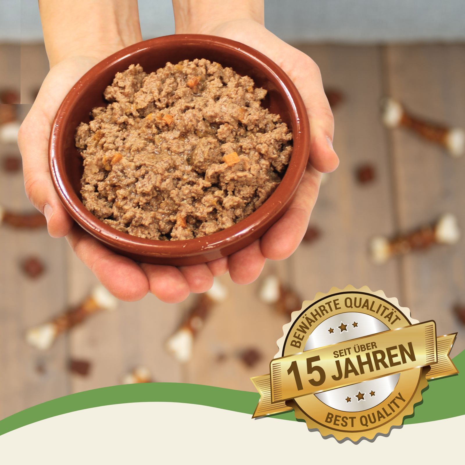 Eine braune Schale mit feuchtem Tierfutter, das aus Hackfleisch und Karottenstücken besteht. Die Schale wird von zwei Händen gehalten.