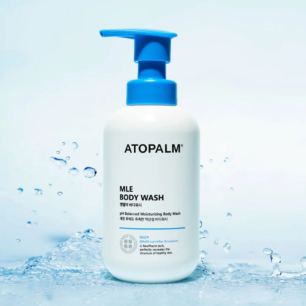 Weiße Flasche mit blauem Pumpkopf. Aufschrift: ATOPALM MLE BODY WASH. Wasser im Hintergrund.