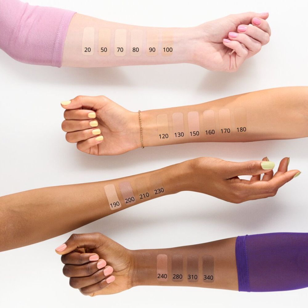 Arme mit Concealer-Farbtönen. Aufschrift: 20, 50, 70, 80, 90, 100, 120, 130, 150, 160, 170, 180, 190, 200, 210, 230, 240, 280, 310, 340.