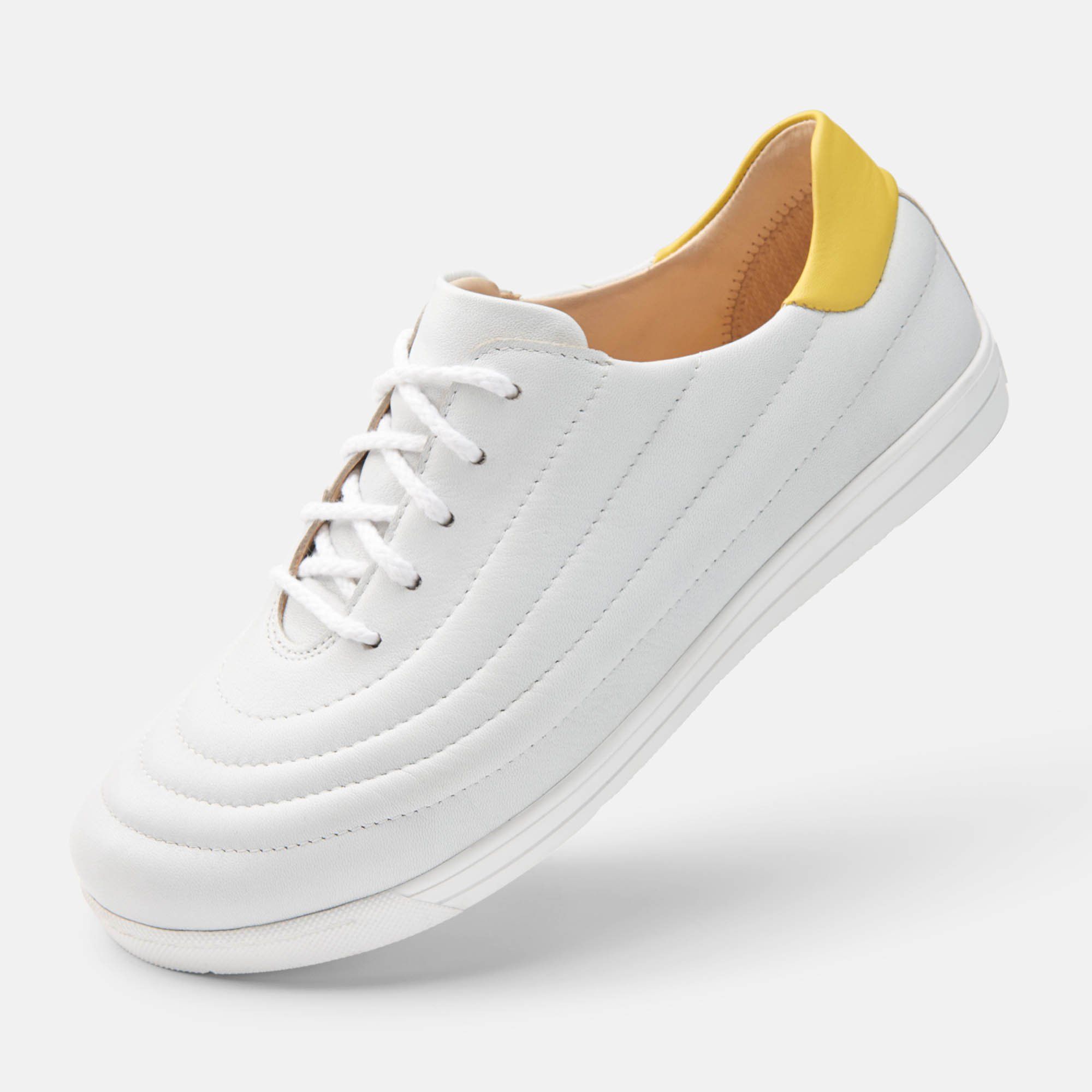 Weißer Schnürschuh mit gelber Fersenkappe. Gepolstertes Design. Flache Sohle.