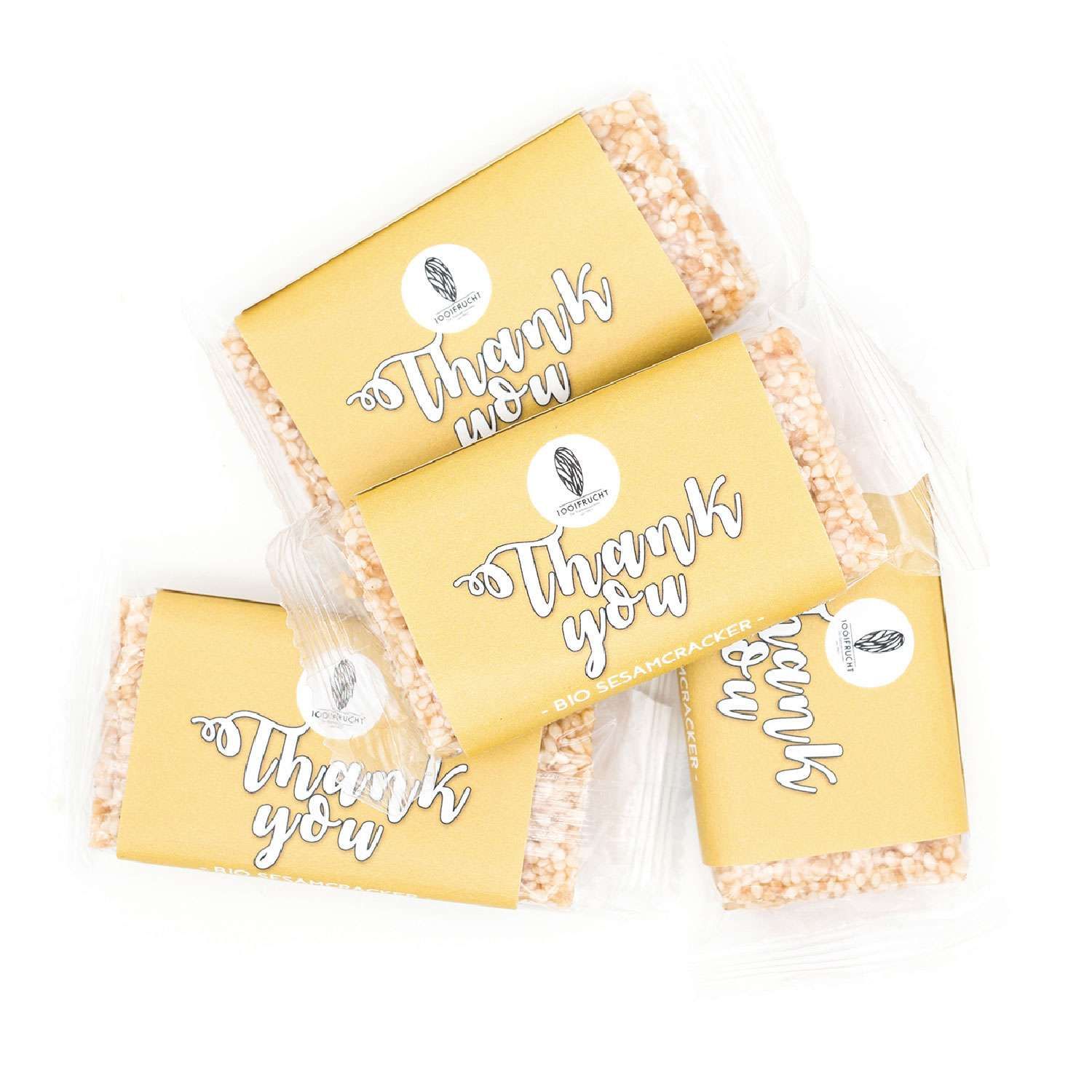 Mehrere Cracker in goldfarbener Verpackung mit "Thank you" Schriftzug. Bio Sesam Cracker.