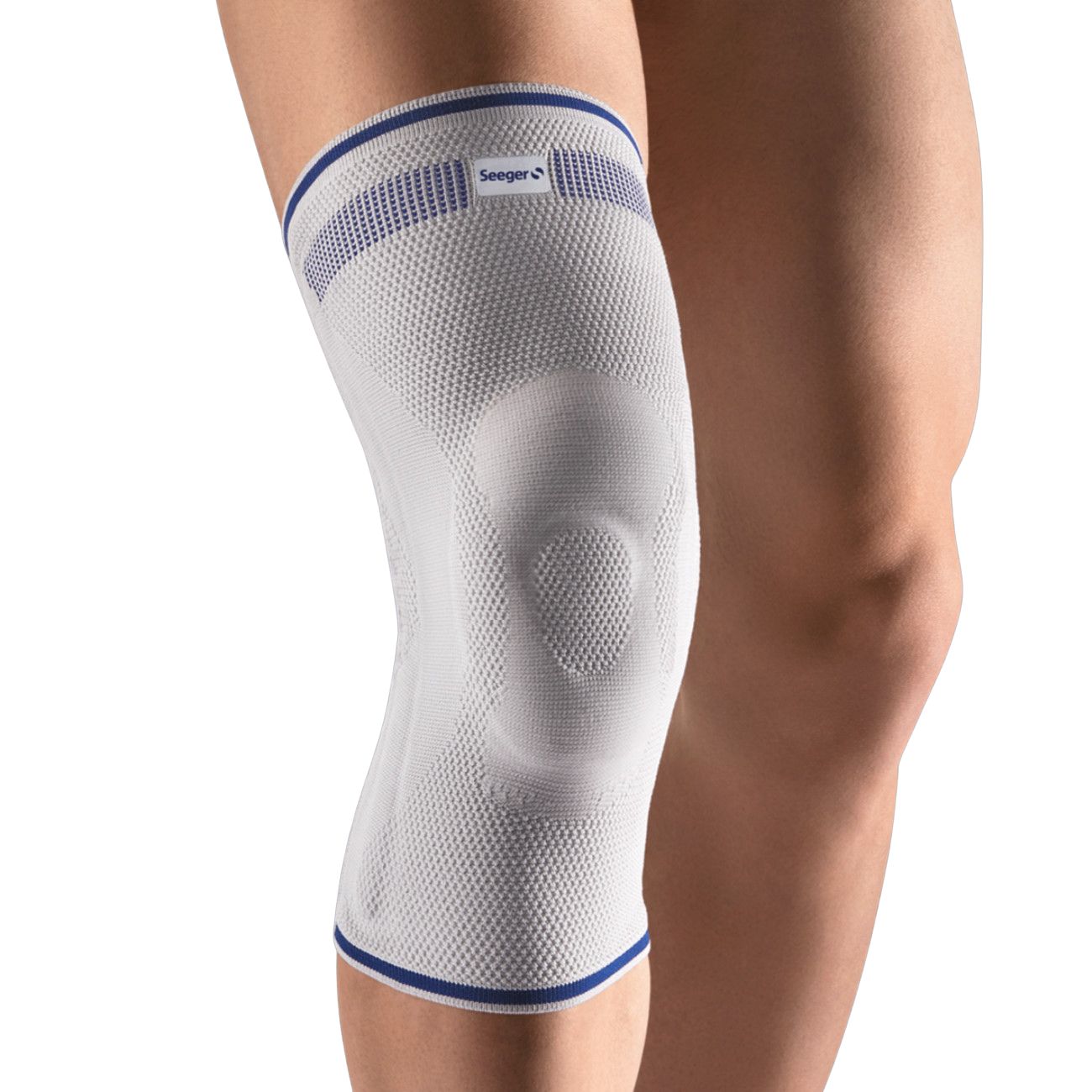 Kniebandage Komfort, weiß mit blauen Akzenten. Seeger-Logo. Elastisches Material, um das Knie getragen. Auf einem Bein platziert.