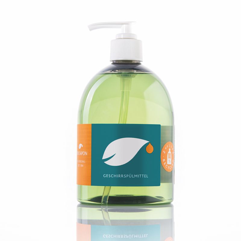 Eine grüne, durchsichtige Spülmittelflasche mit weißem Pumpkopf. Auf dem Etikett steht "Geschirrspülmittel" und ein Blatt-Tropfen-Logo. Die Flasche ist aus Kunststoff und steht auf einer reflektierenden Oberfläche.