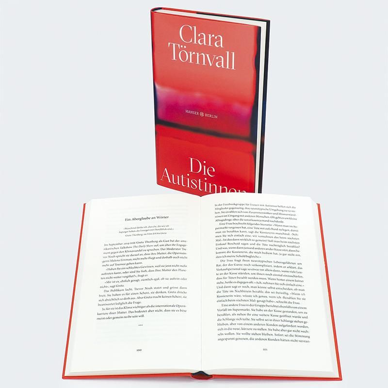 Buch "Die Autistinnen" und offene Ausgabe. Roter Einband. Titel: Clara Törnvall. Verlag: Hanser Berlin.