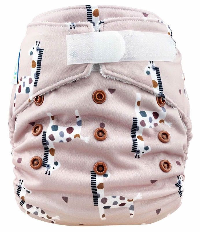 Stoffwindel mit Giraffenmuster und Klettverschluss. Braune Druckknöpfe. Rosa Stoff mit weißen Giraffen.