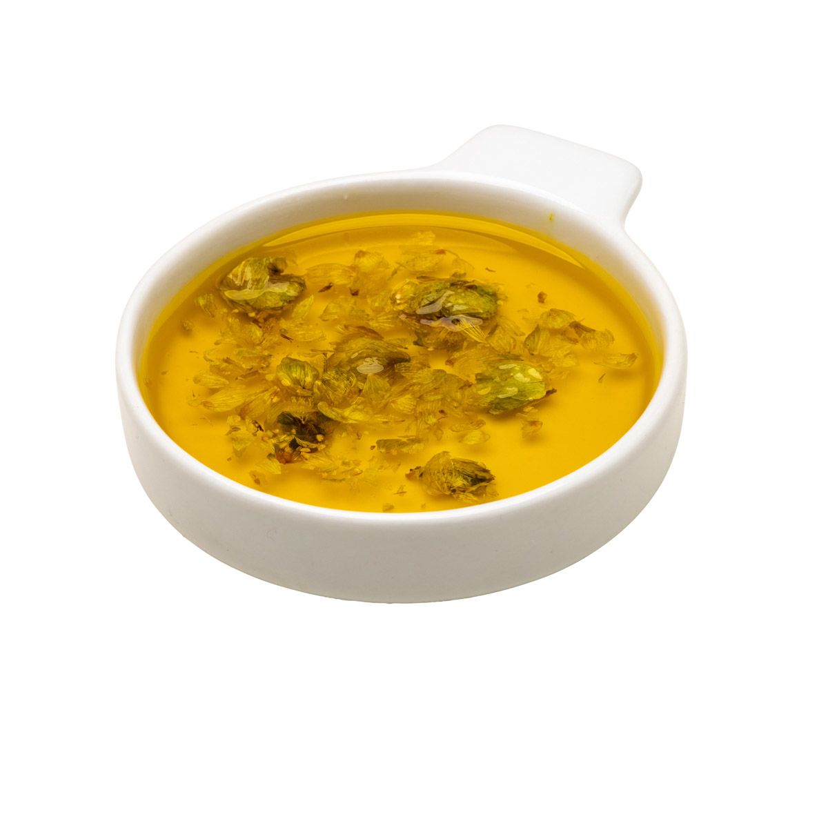 Kleine weiße Schale mit gelber Flüssigkeit und Kräutern. Flüssigkeit mit Kräutern gefüllt.