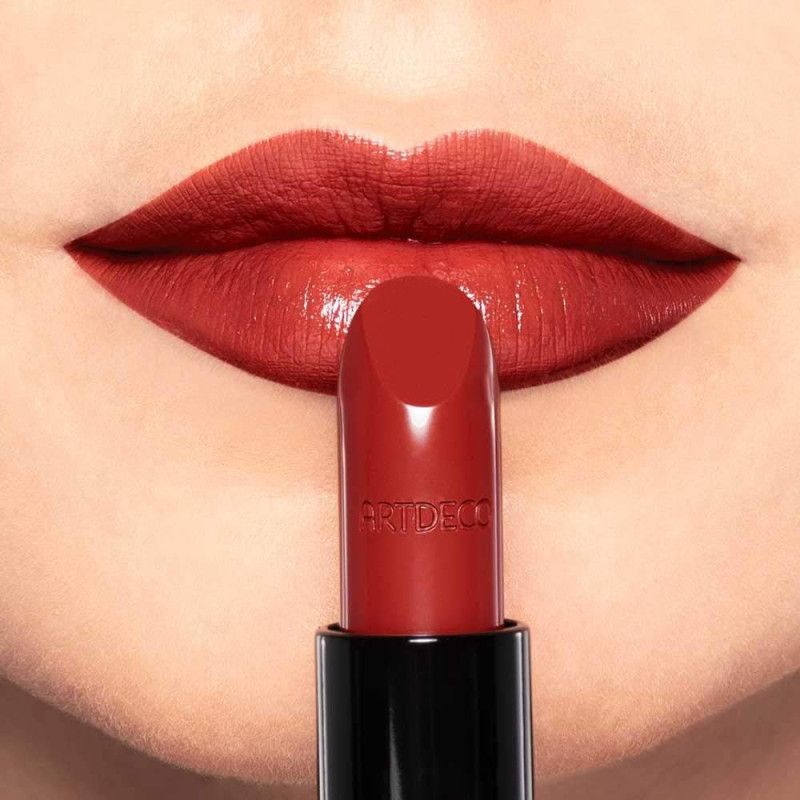 Roter Lippenstift wird auf volle Lippen aufgetragen. ARTDECO Logo auf dem Lippenstift.