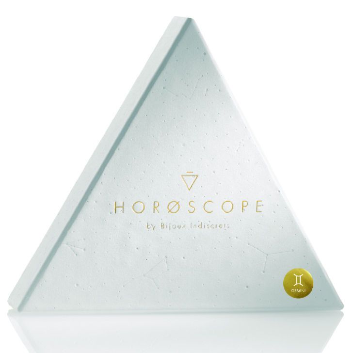 Geschlossene, dreieckige Box. Aufschrift: HOROSCOPE by Bijoux Indiscrets. Mit Sternzeichen-Symbol.