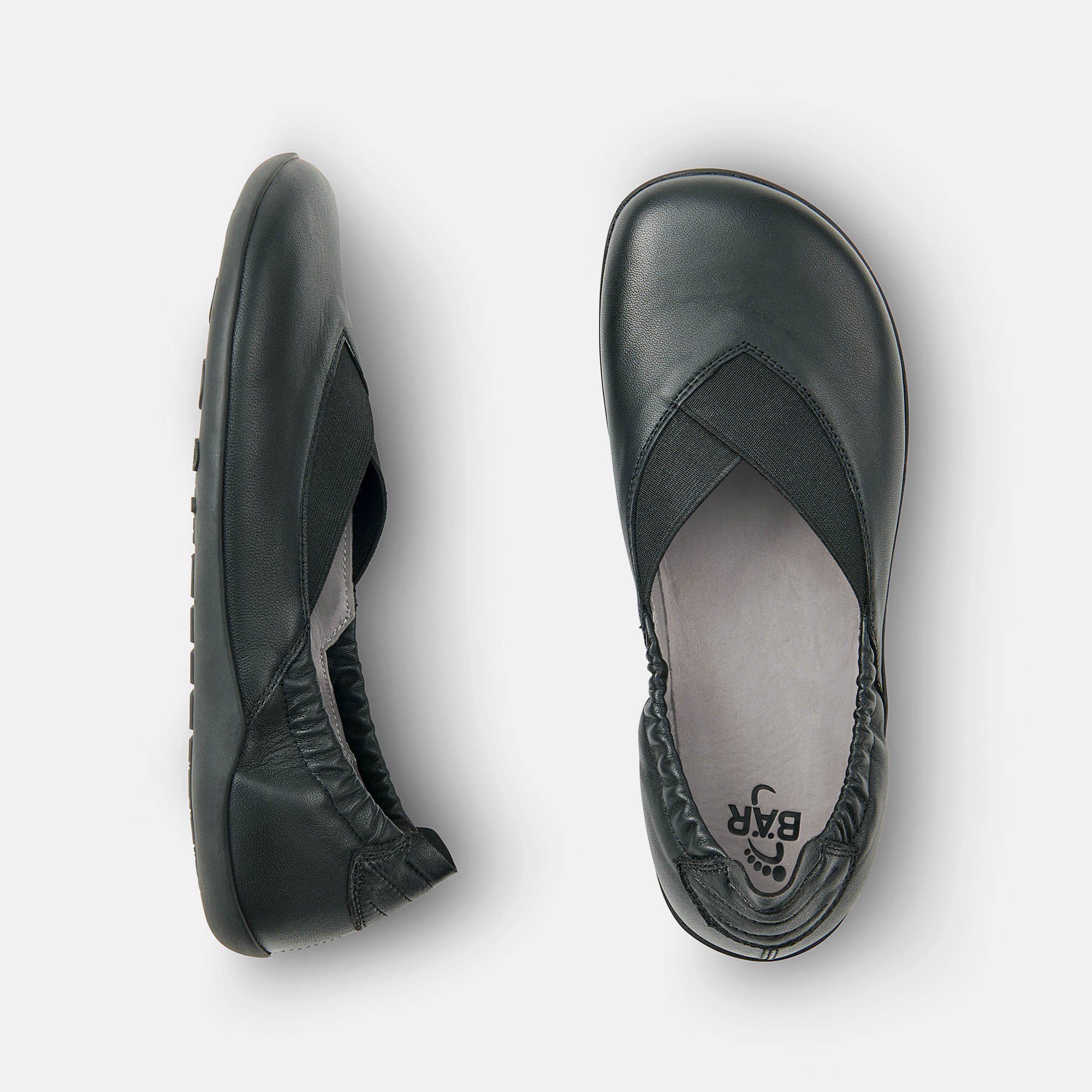Zwei schwarze Ballerinas. Leder, elastischer Einsatz. Weite Form. Draufsicht, eine Sohle mit Logo.