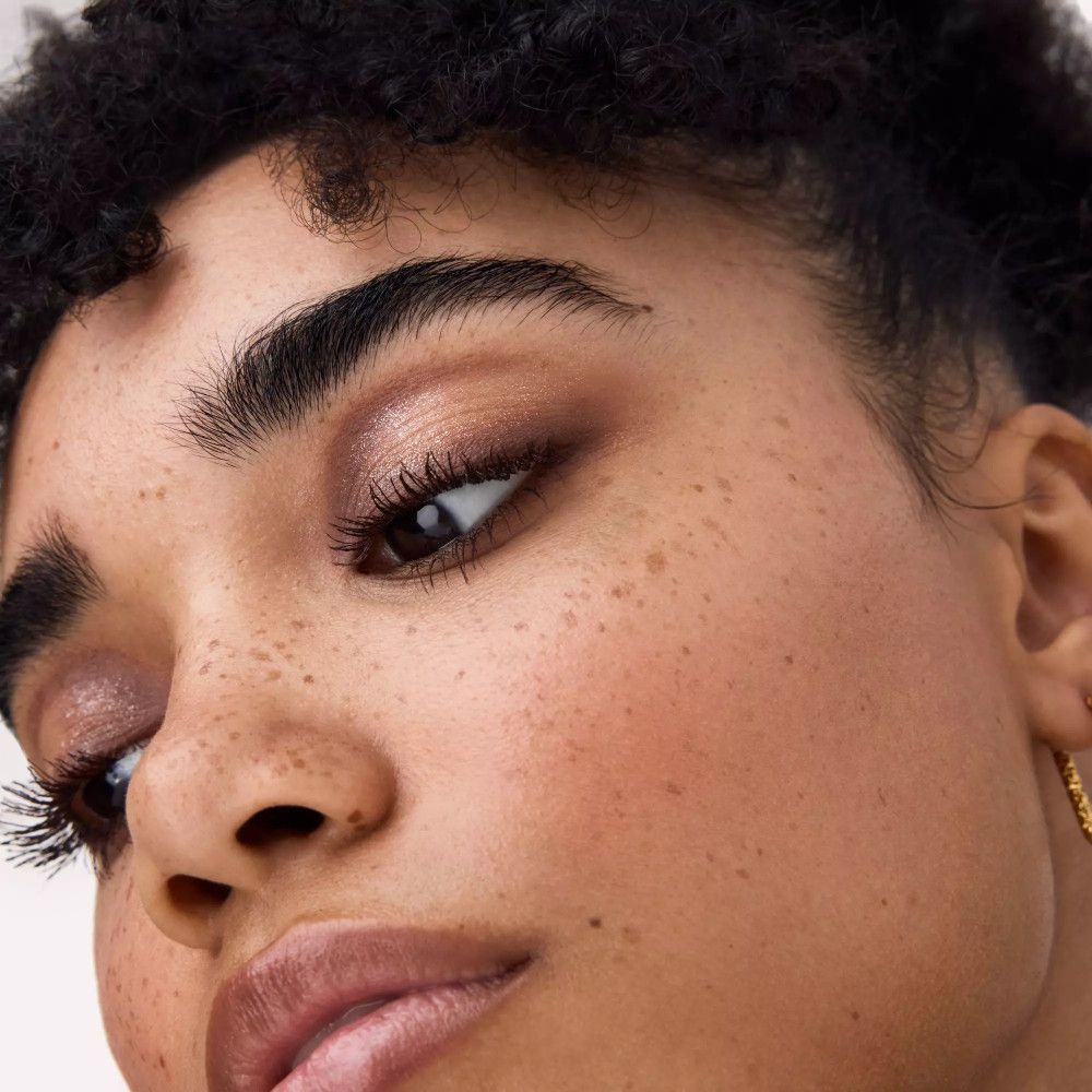 Nahaufnahme eines Gesichts mit geschminkten Augen. Der Lidschatten ist in Brauntönen gehalten.