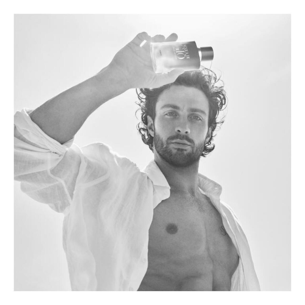 Schwarz-Weiß-Foto eines Mannes, der einen Parfümflakon hält. Text: „Acqua di Giò Profondo“.