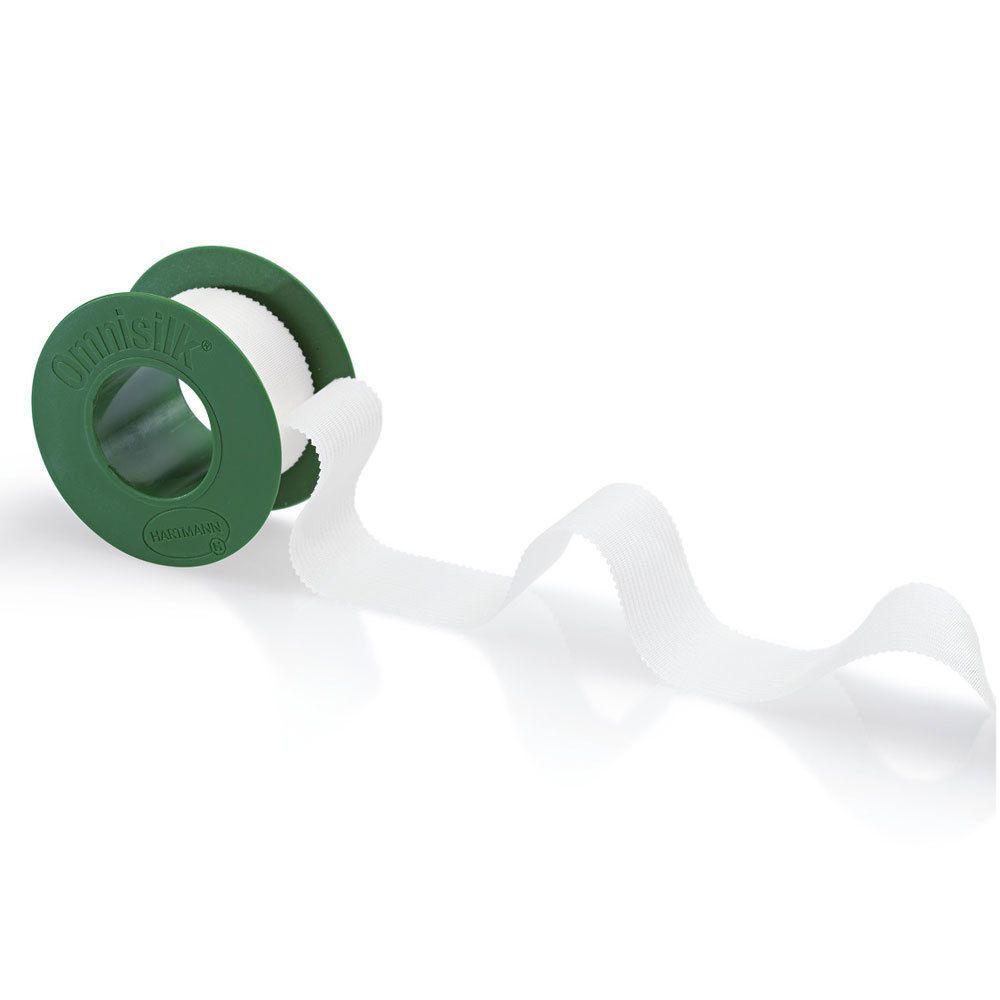 Rolle weißes Pflaster, grüner Kern. Pflasterband abgerollt. Aufschrift: Omnisilk.
