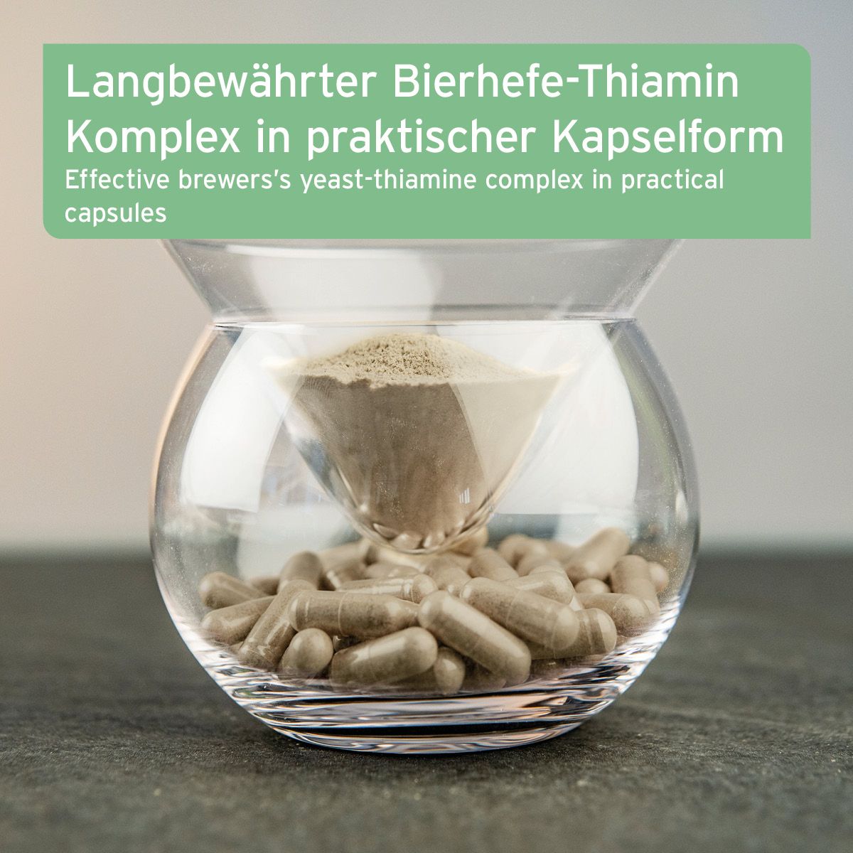 Glasbehälter mit Kapseln und Pulver. Text: Bierhefe-Thiamin Komplex in Kapselform. Braune Kapseln, hellbraunes Pulver.