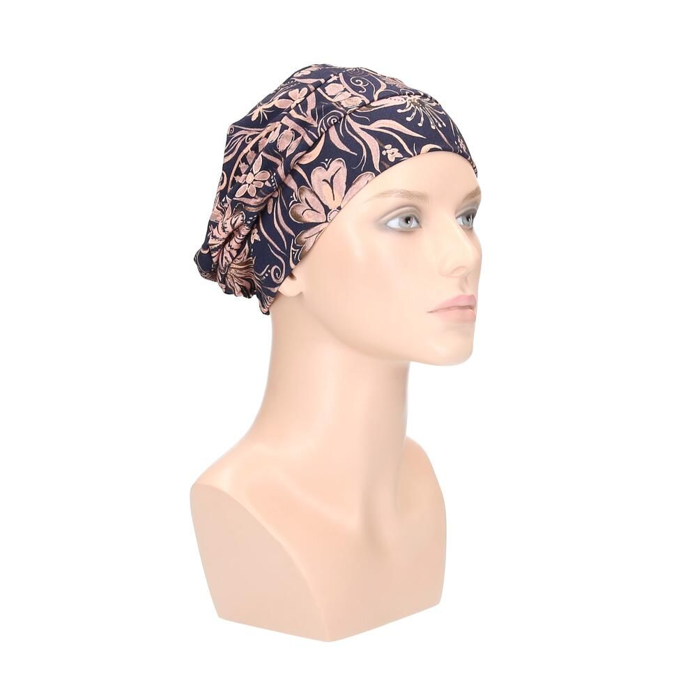 Blauer Turban mit floralem Muster auf einer Büste. Dreiviertelansicht.