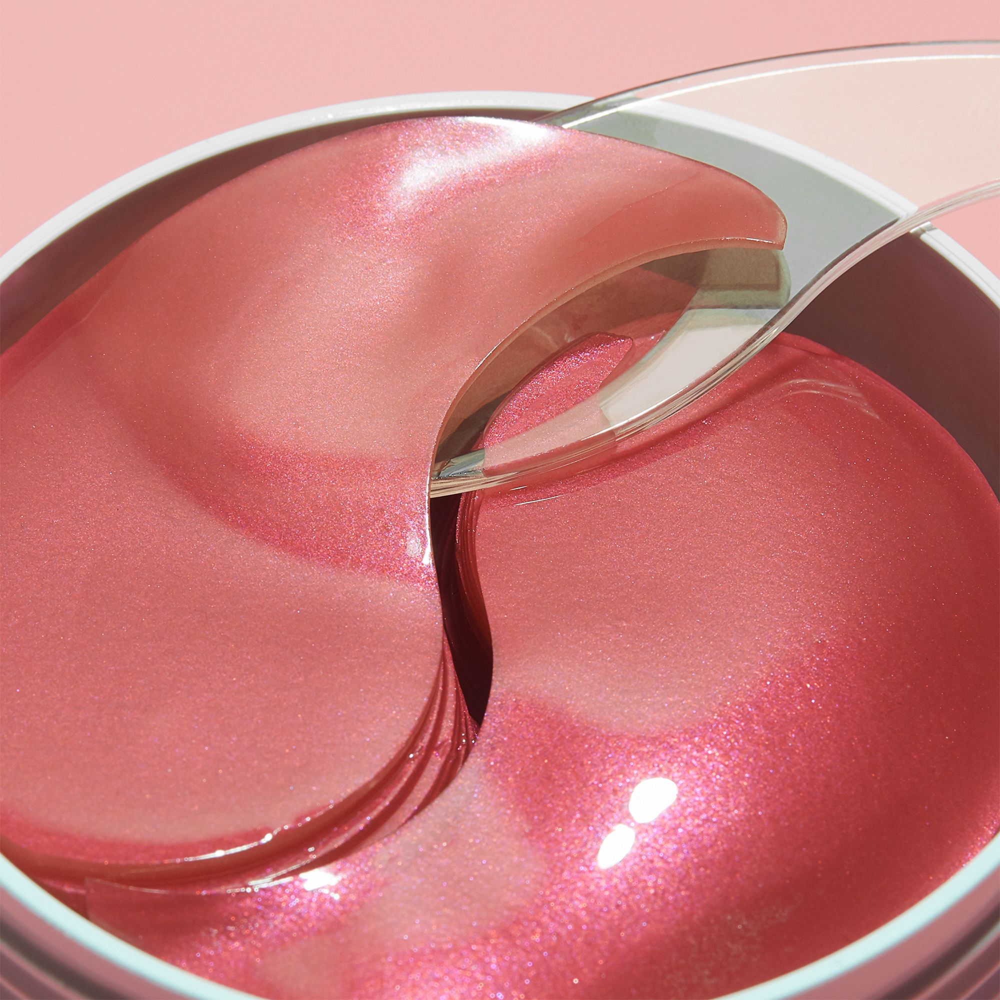 Nahaufnahme von Augenpads. Rosa, glänzende Pads in einer Dose. Transparenter Spatel.