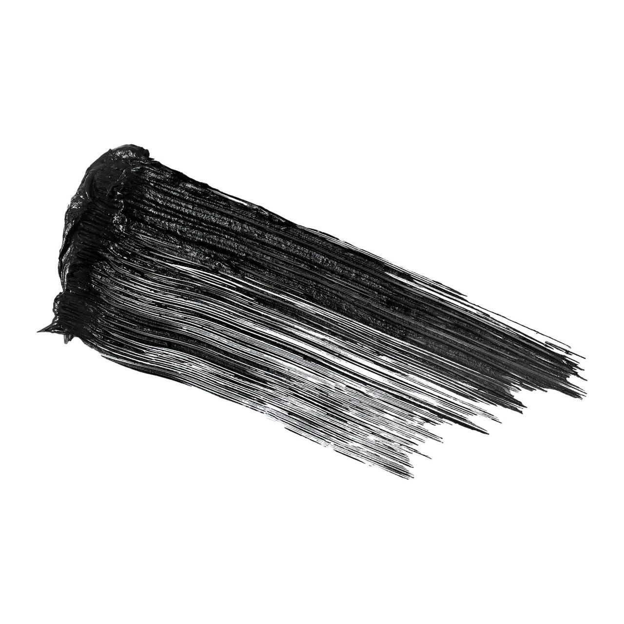 Schwarzer Mascara-Strich auf weißem Hintergrund. Die Textur ist glatt und deckend.