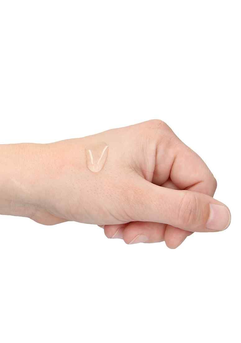 Hand mit einem Tropfen durchsichtigem Gel auf der Haut.