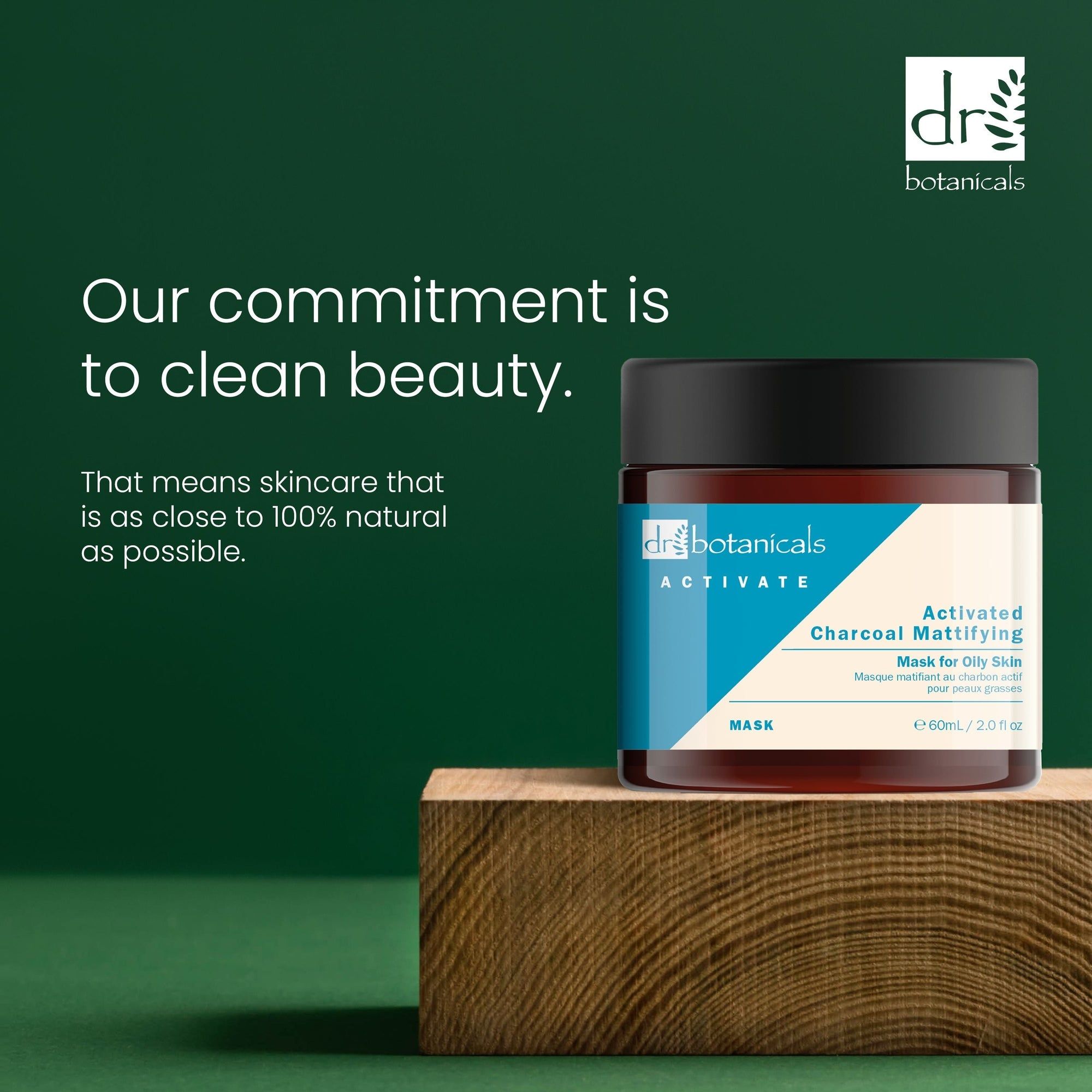 Braune Glasdose mit schwarzem Deckel auf Holzblock. Text: Our commitment is to clean beauty. Activated Charcoal Mattifying Mask.