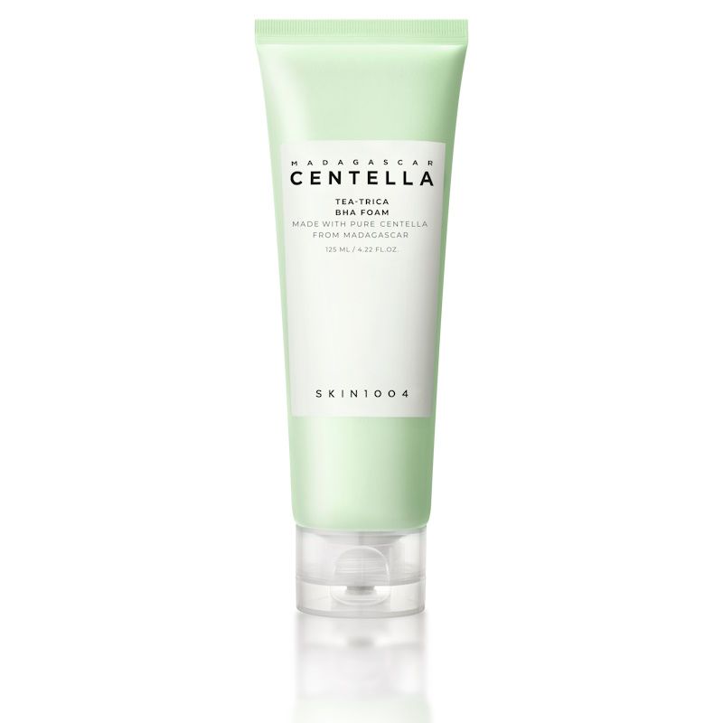 Tubo verde chiaro con etichetta bianca. Scritta: MADAGASCAR CENTELLA, TEA-TRICA BHA FOAM, SKIN1004. Chiusura trasparente.