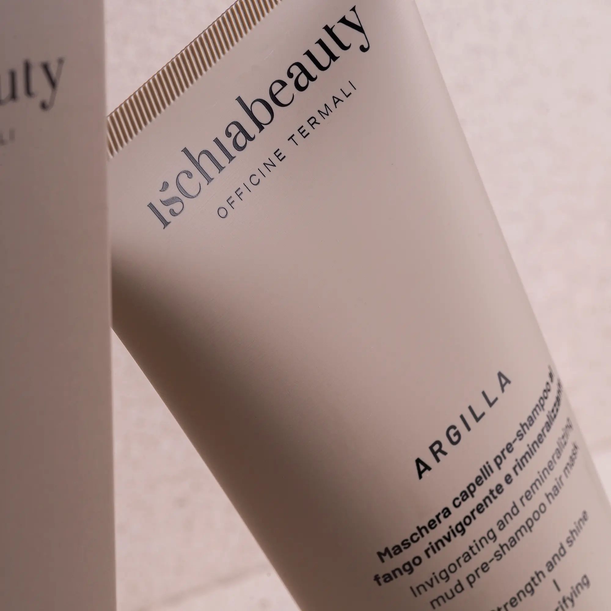 Nahaufnahme einer Tube mit Produktaufschrift: ischiabeauty, ARGILLA, Maske für Haare.