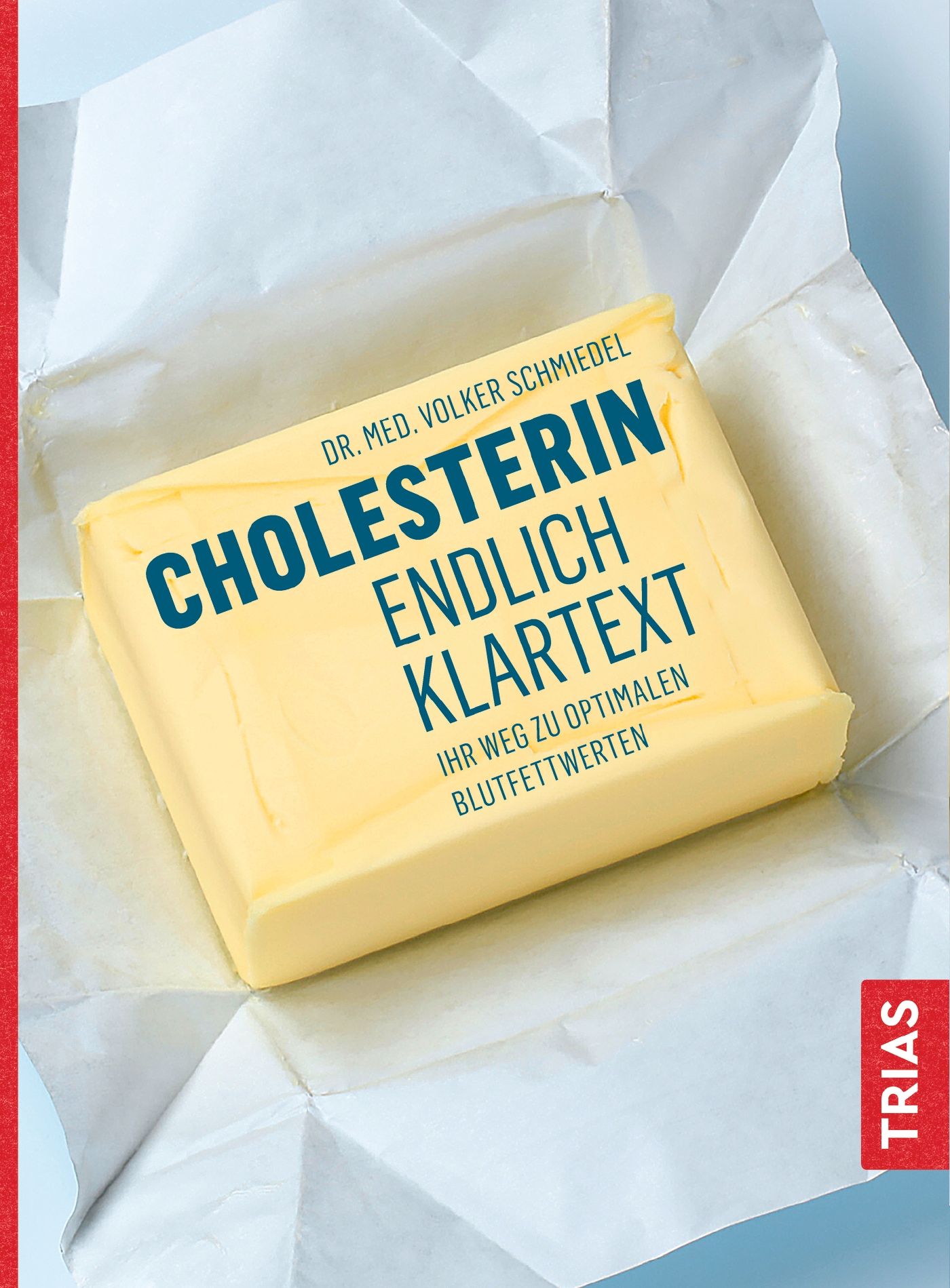 Buch "Cholesterin - endlich Klartext" von Dr. med. Volker Schmiedel. Auf weißem Papier, mit blauem Text. Verlag: TRIAS.
