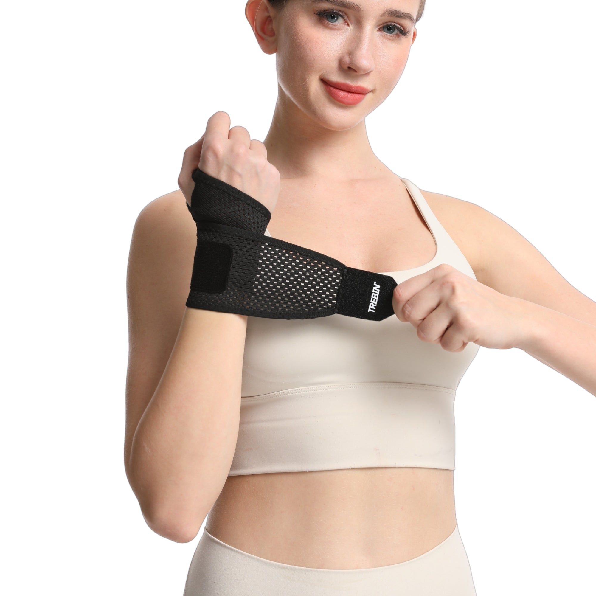 Frau trägt eine schwarze Handgelenkbandage, die sie anpasst.