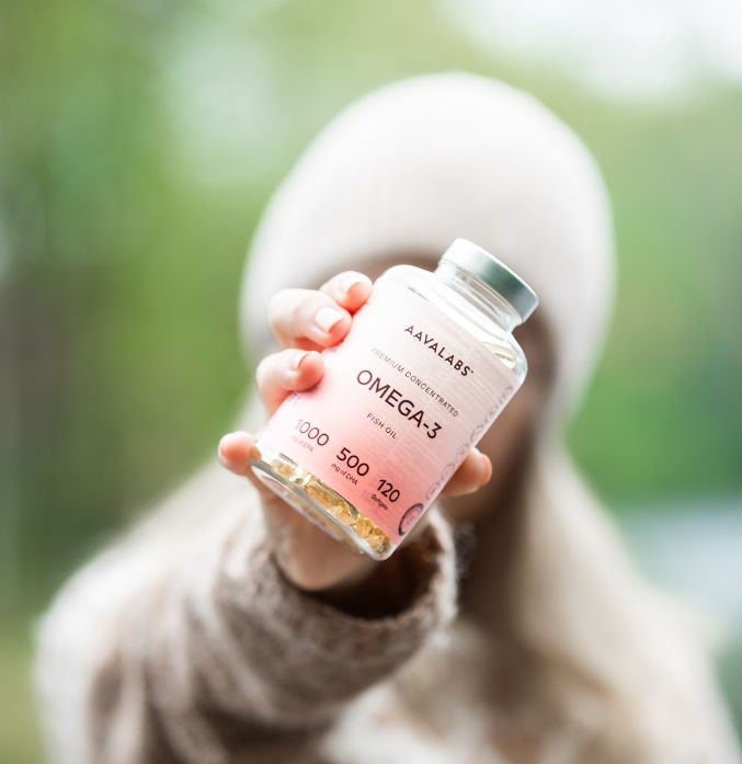 Person hält eine Flasche Aavalabs Omega-3 Fischöl in die Kamera.