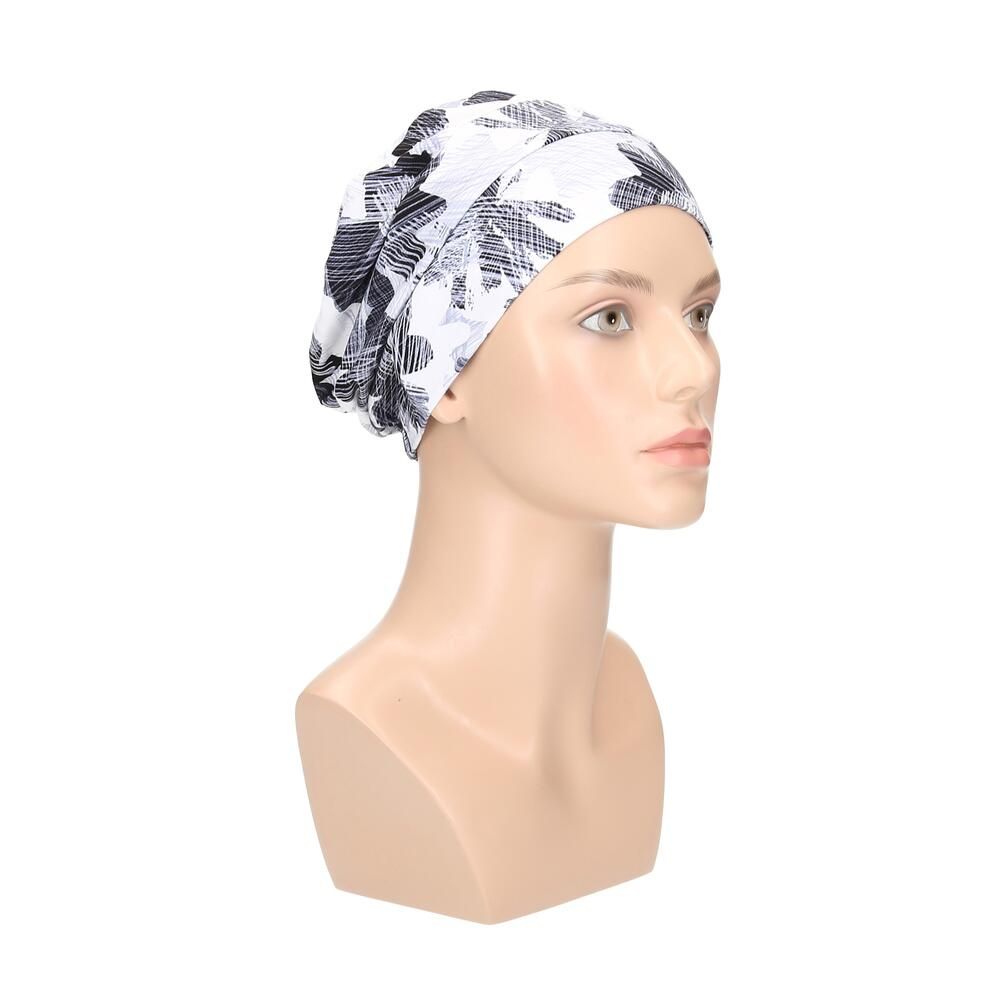 Turban mit floralem Muster in Weiß, Grau und Schwarz. Dreiviertelansicht auf einer Büste.