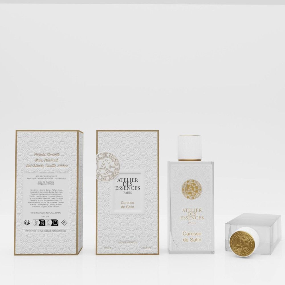Parfumflakon, Verpackung und Deckel. Aufschrift: Atelier des Essences, Paris, Caresse de Satin. Goldfarbene Details.
