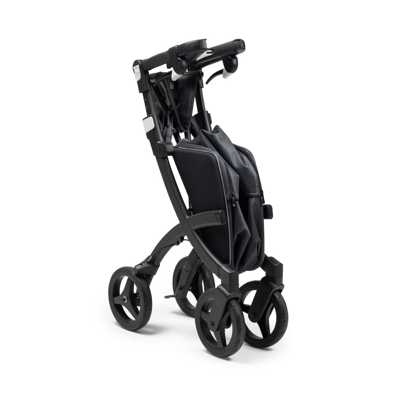 Zusammengeklappter Rollator, schwarz. Vier Räder, Handgriffe und Tasche.