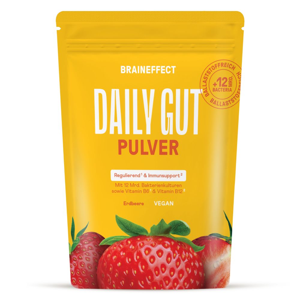 Gelbe Verpackung mit Produktnamen und Erdbeeren. Text: Daily Gut Pulver, Erdbeere, Vegan. Enthält Bakterienkulturen, Vitamin B6 & B12.
