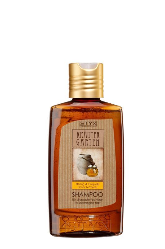 Braune Shampoo-Flasche mit goldfarbenem Deckel. Auf dem Etikett steht "STYX Kräuter Garten" und "Honig & Propolis".
