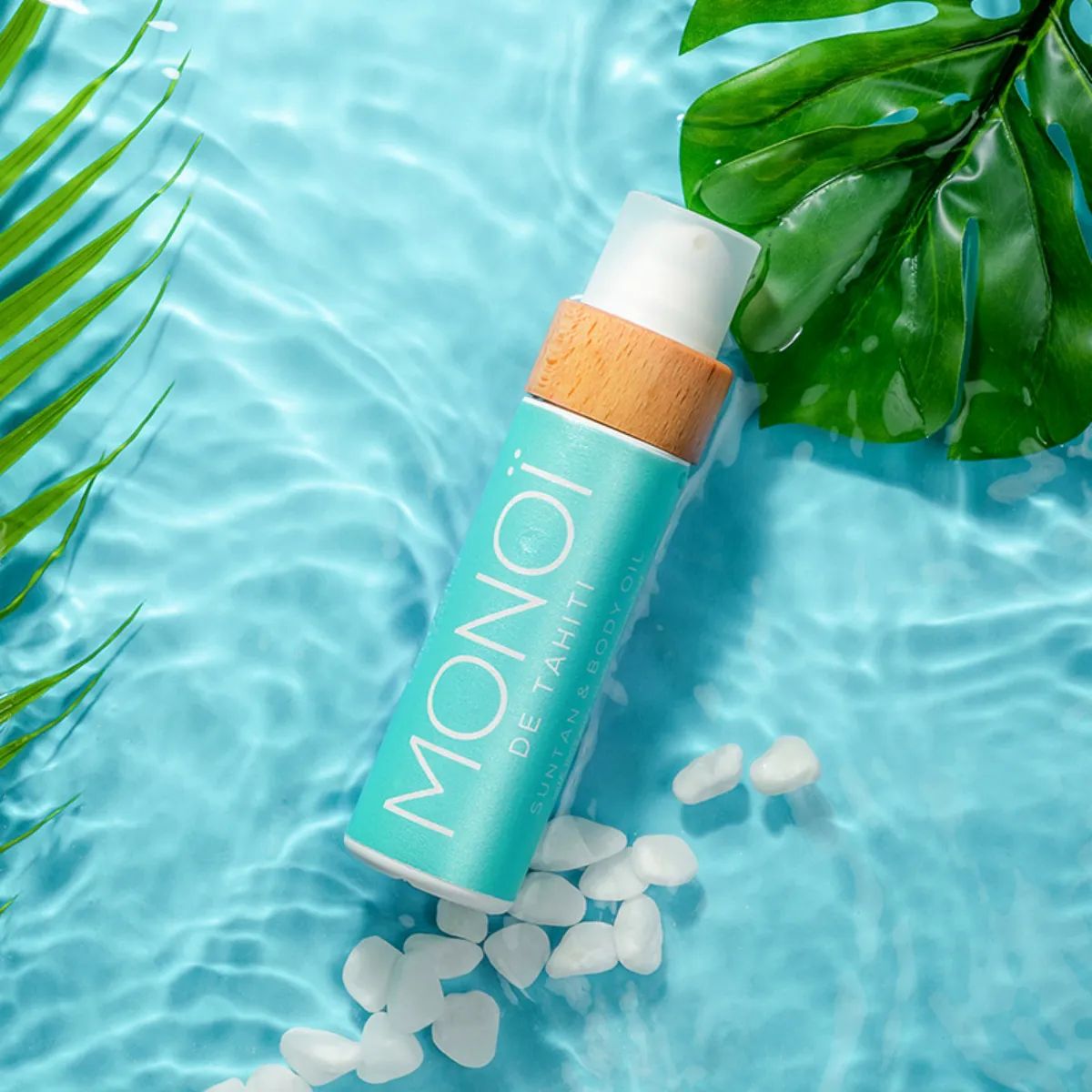 Flasche COCOSOLIS MONOÏ DE TAHITI Öl auf blauem Wasser.