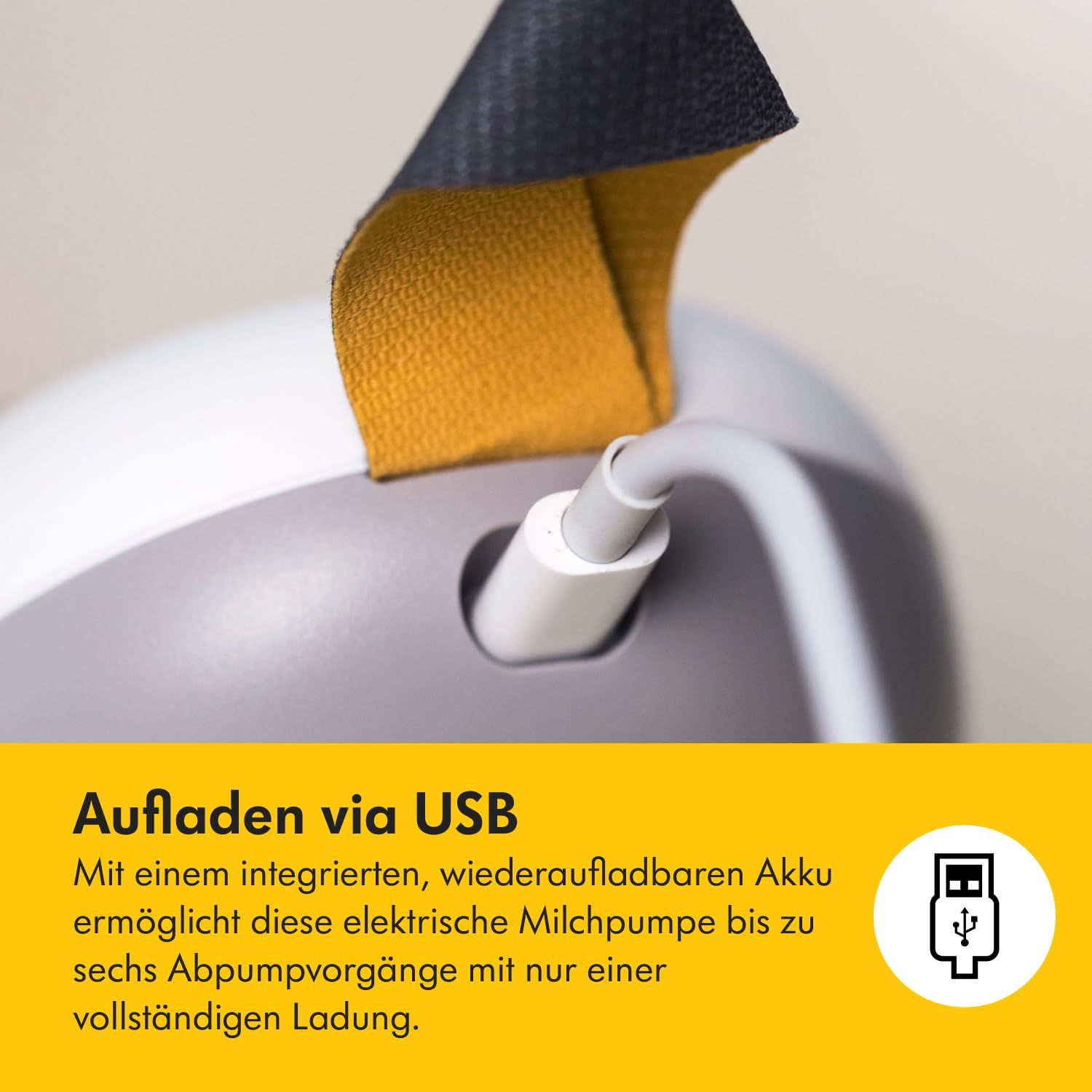 Medela Solo™ Elektrische Milchpumpe. Detail: USB-Anschluss. Gelber Hintergrund.
