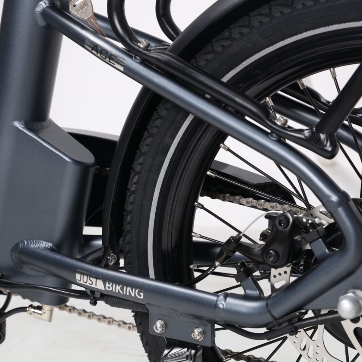 E-Bike-Rahmen mit JUST BIKING-Schriftzug. Graue Farbe, Gepäckträger und Hinterradbremse.