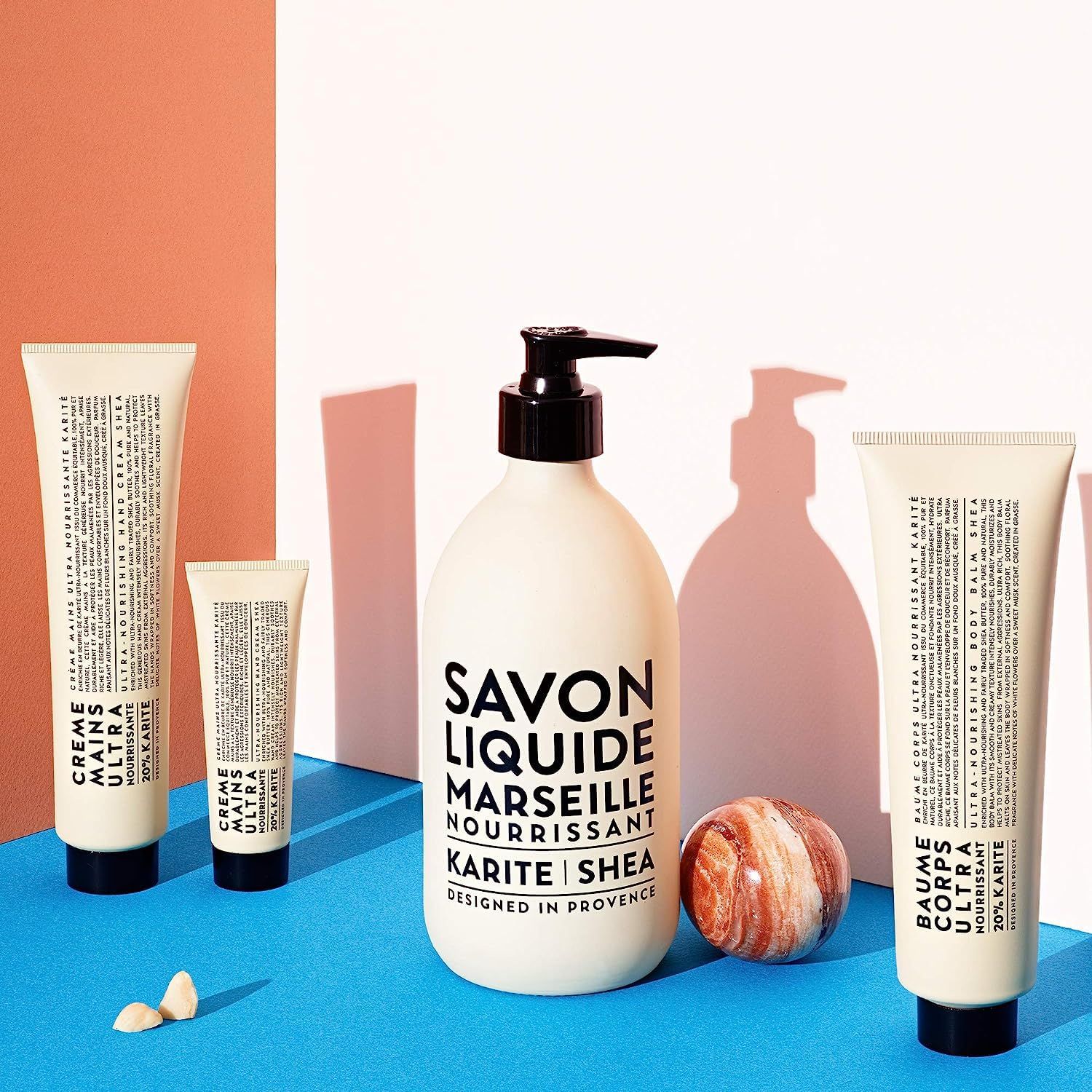 Produkt-Set mit Flasche, Tuben und Kugel. Text: Savon Liquide Marseille, Karité/Shea. Creme Mains Ultra, Baume Corps Ultra.