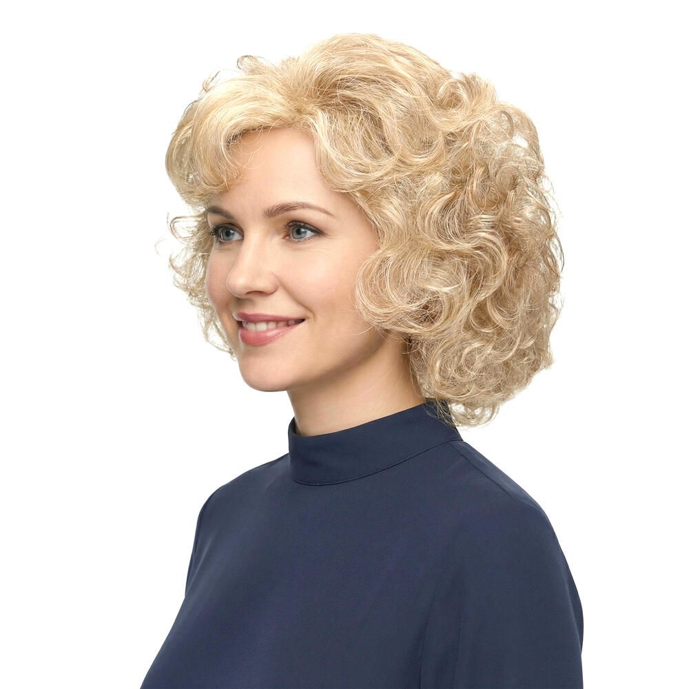 Blonde Lockenperücke, Seitenansicht. Frau mit blauem Oberteil, lächelnd. Weißer Hintergrund.