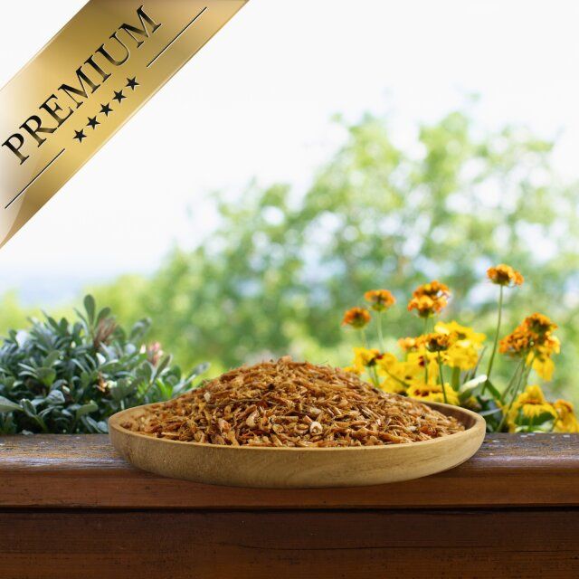 Getrocknete Shrimps in einer Holzschale. Im Hintergrund Blumen und Fenster. Aufschrift: PREMIUM.