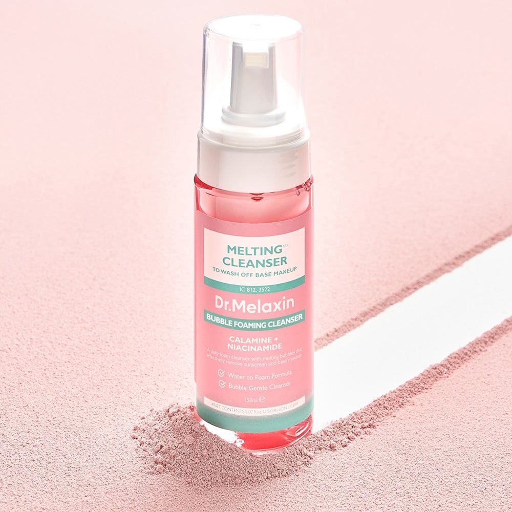 Dr. Melaxin Bubble Foaming Cleanser auf einem rosa Untergrund mit Pulver.