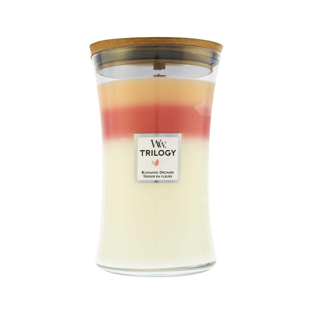 Dreifarbige Duftkerze mit Holzdocht. Glasbehälter mit Deckel. Etikett mit "Trilogy" und "Blooming Orchard".