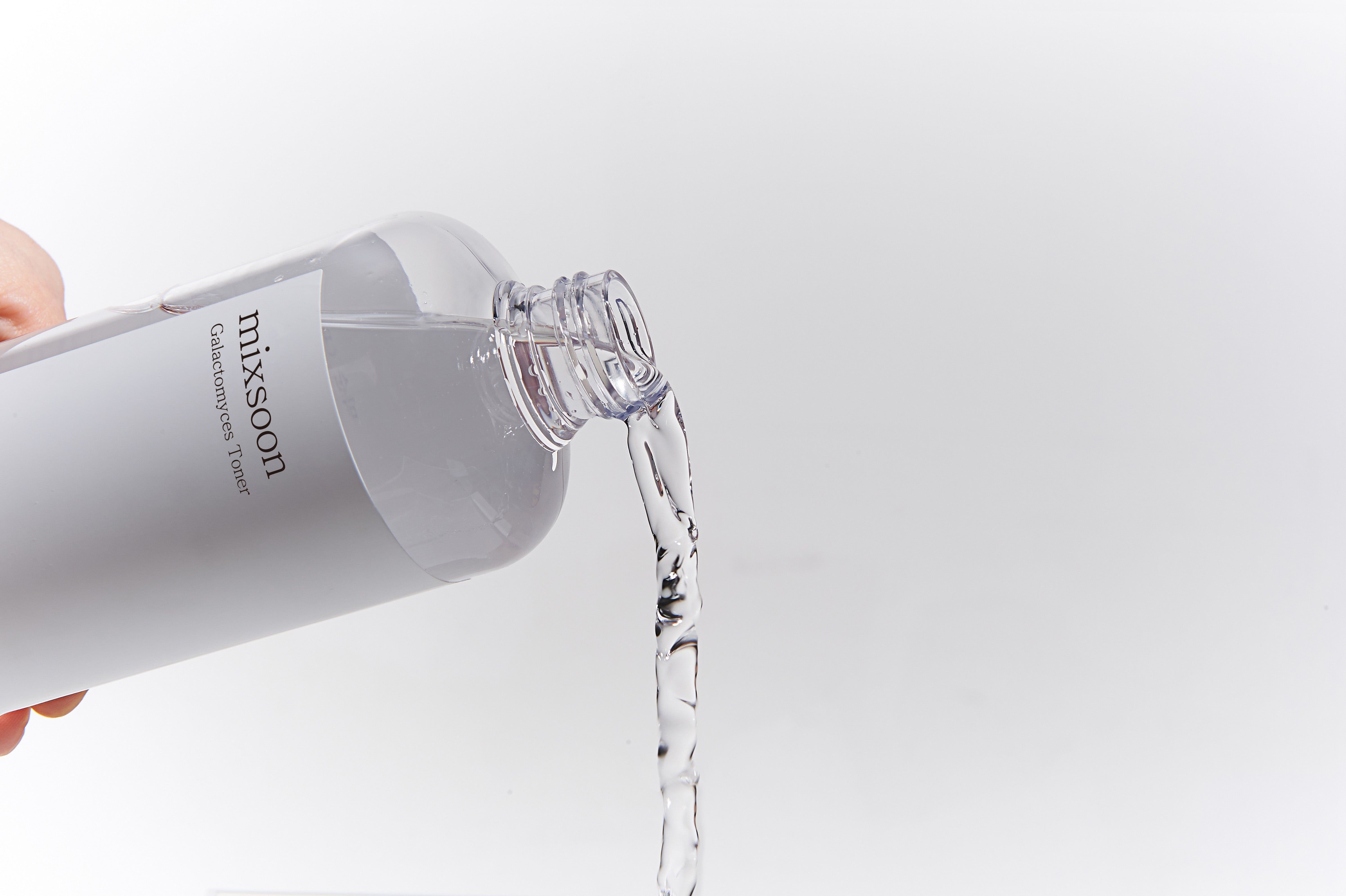 Klare Flüssigkeit fließt aus einer Flasche. Aufschrift: mixsoon Galactomyces Toner. Flasche teilweise sichtbar.