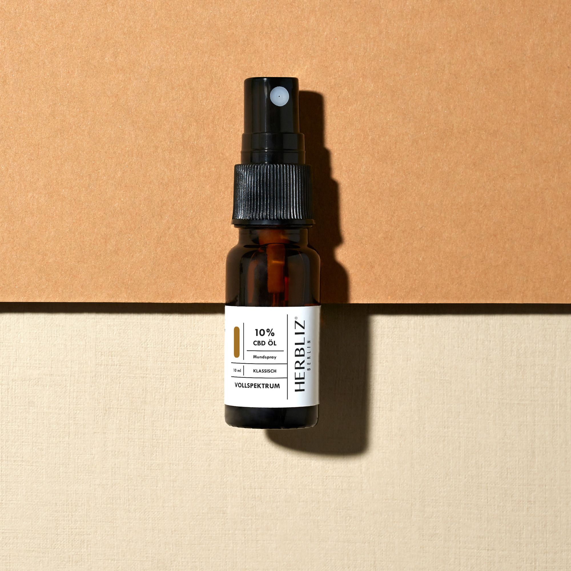 Braune Glasflasche mit schwarzem Sprühkopf. Aufschrift: 10% CBD, HERBLIZ, Vollspektrum, Klassisch.