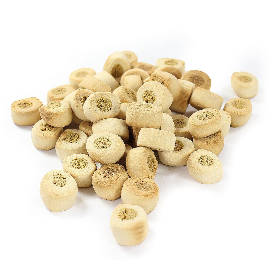 Hundekekse in Rollenform, beige mit hellem Kern. Auf weißem Hintergrund, lose angeordnet.