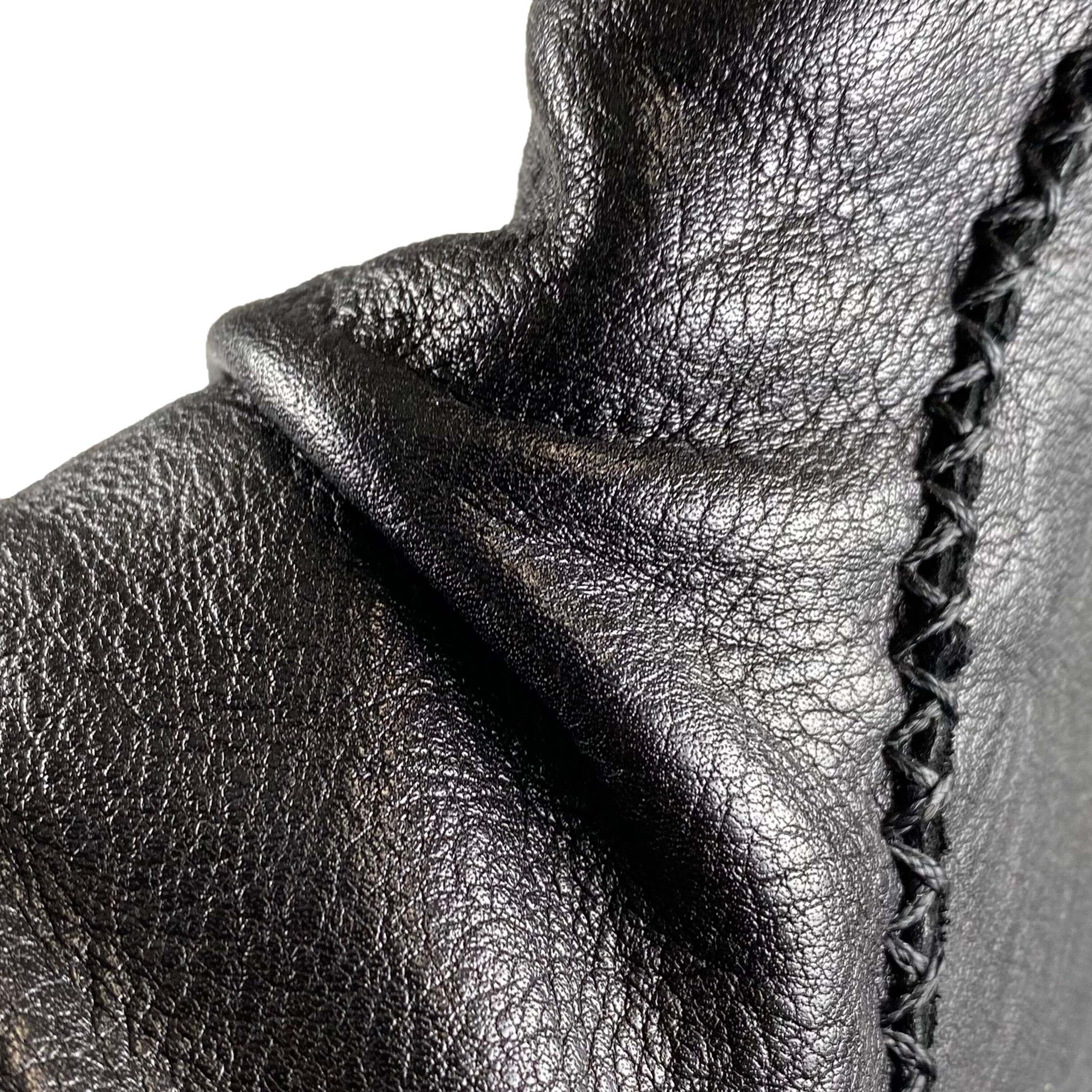 Detailansicht des gerafften Lederschafts mit Ziernaht einer schwarzen Stiefelette.