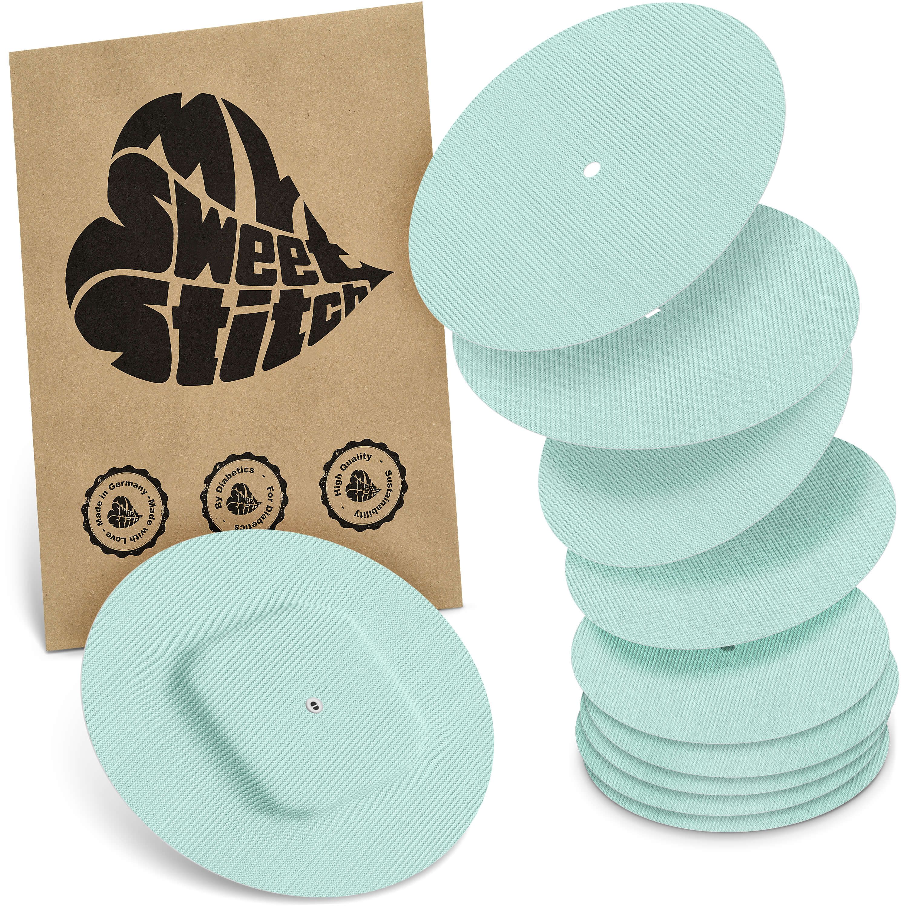 Hellgrüne, runde Pflaster mit geriffelter Oberfläche. Neben einer braunen Verpackung mit Logo und Siegeln.